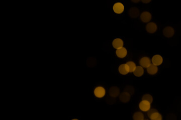 gold bokeh light on black background © Natheepong