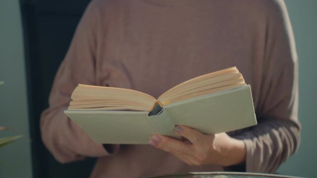 Unrecognizable woman read book on terrace in daylight. Education, learning, self development and knowledge concept enjoy literature as peaceful and relaxing hobby. Calm outdoor study environment.