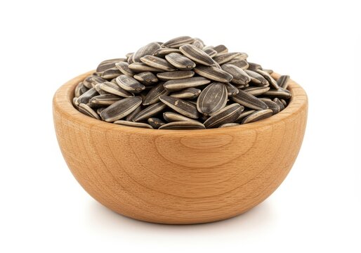 A small rustic wooden bowl filled to the brim with raw, unshelled sunflower seeds. Healthy snack ingredient presented on a white background, nutrition, plant food, raw