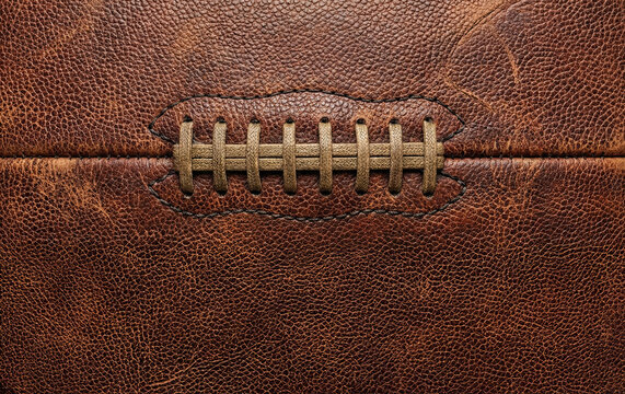 American Football Texture: A close-up view showcasing the intricate details of an American football, highlighting its rich textures and the meticulous craftsmanship of its stitching.