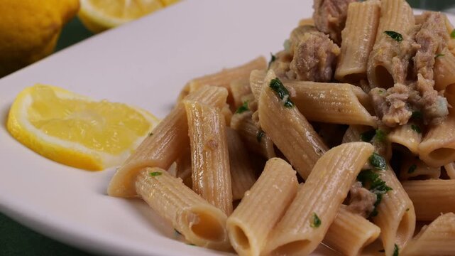 Primo piano di piatto con penne al tonno e limone con prezzemolo