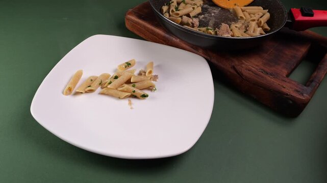 Il cuoco prende la pasta dalla padella e la mette nel piatto