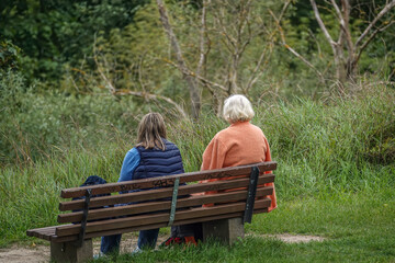 zwei Frauen sitzen auf einer Sitzbank im Park