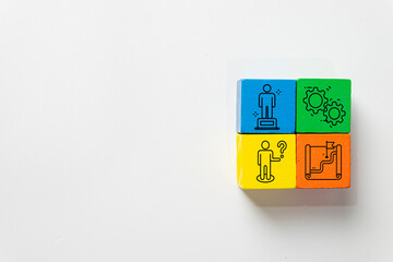 Business strategy and management process concept. Colorful wooden blocks with icons of leadership, gears teamwork, problem solving, and roadmap goal on white background with copyspace.