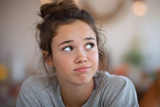 Teen girl rolling eyes slightly during discussion, subtle frustration.