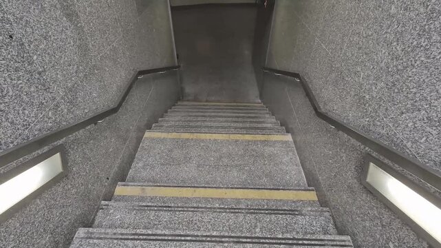 stairs are made of gray granite. edges of stairs are marked with yellow markings for better visibility and anti-slip tapes. in low visibility or when wet. stainless steel railing is installed on sides