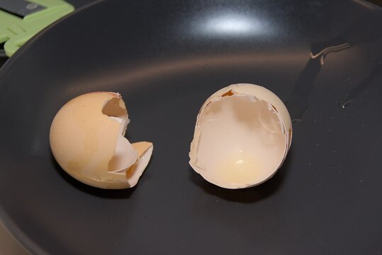Broken Raw Egg Shells in Dark Frying Pan