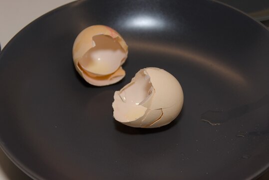 Broken Raw Egg Shells in Dark Frying Pan