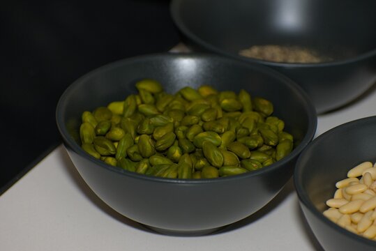 Shelled Green Pistachio Kernels in Black Ceramic Bowl
