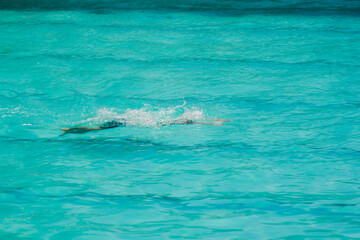 Asian child competing swimmer in the swimming pool