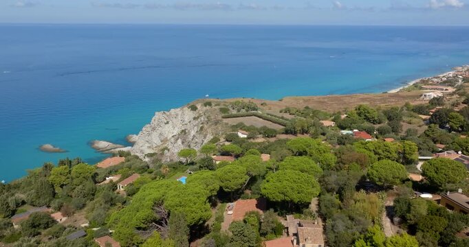 Aerial view of the Capo Vaticano promontory, in Calabria, Italy. It is the outermost cape of the Coast of the Gods. There are some houses and villas perched on the promontory overlooking the sea.