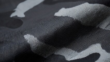 Detailed closeup of a grey camouflage pattern on a textured fabric revealing the weave structure