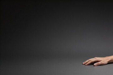 Minimal dark studio background with resting human hand