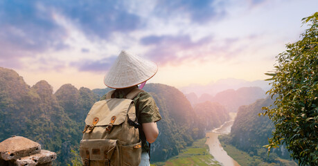 Young asian woman admiring stunning Ninh Binh landscape at sunset