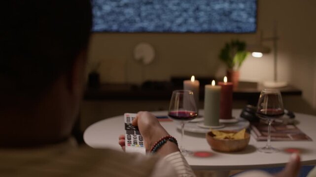 Close up of unrecognizable man holding remote controller, pushing bottoms, trying to repair broken TV to watch movie with wife