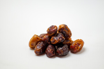 Obraz premium Close Up of a Small Pile of Sweet Brown Dates on a Clean White Background