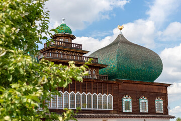 Building with green domes and wooden structure in a natural setting on a sunny day