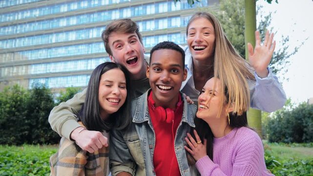 Happy group of students enthusiastically waving and smiling at the camera, showcasing friendship and joy in a carefree outdoor environment, perfect for capturing youthful moments of togetherness.