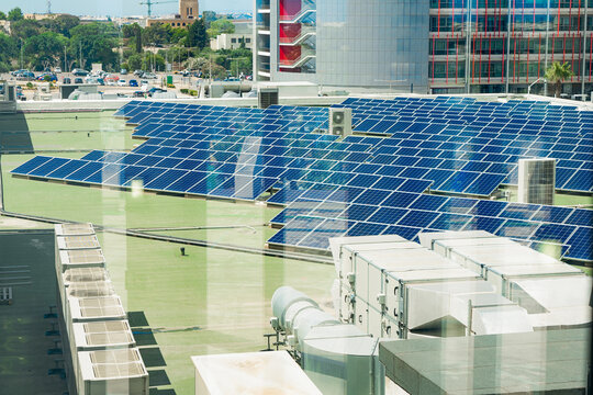 Rooftop solar farm above modern offices, solar output cuts emissions, solar investment fits ESG strategy, sustainable city energy concept for green business, climate content
