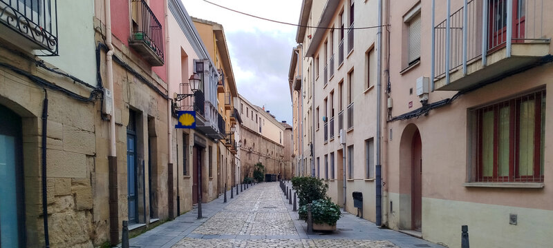 Calle estrecha empedrada con edificios antiguos bajo un cielo nublado en Logro&ntilde;o, La Rioja