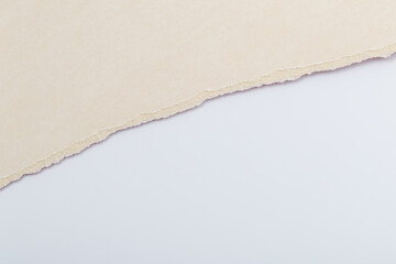 Torn paper showing a layer of beige and white as background with soft textures and subtle color changes