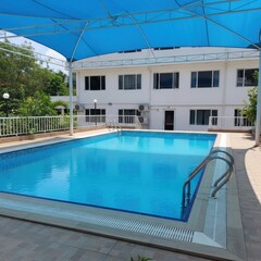 Modern building with a large outdoor swimming pool and a unique dome structure in the background