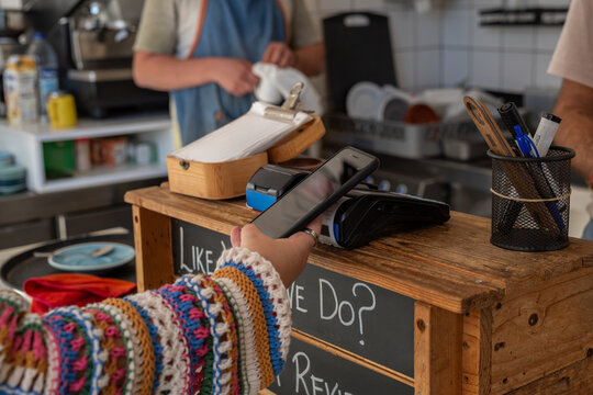 Woman paying at cafe using NFC