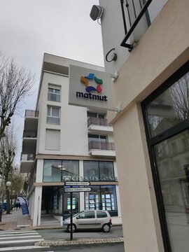 Saintes, France - January 28, 2026: Matmut insurance agency sign on a modern building facade with residential apartments and a parked car visible in the foreground