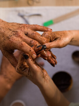 Woman massaging hands of anonymous man with scrub 