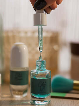 Woman holding dropper with beauty product 