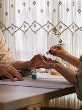 Beautician applying cuticle remover