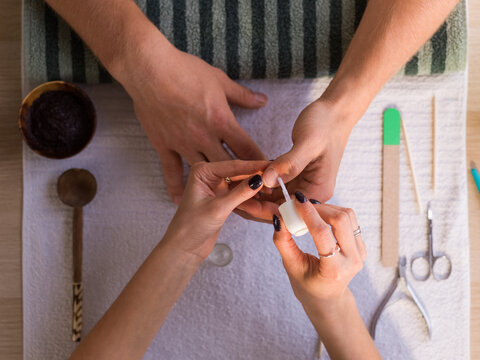 Manicurist applying cuticle remover