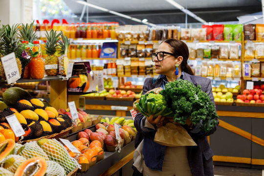 Woman Chooses Produce at a Grocery Store 