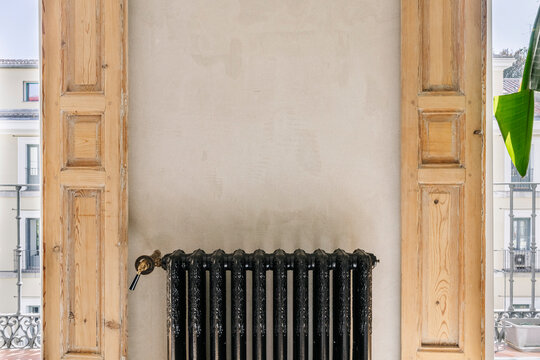 Radiator Between Wooden Shutters