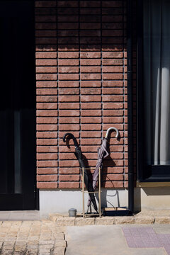 Umbrellas by Brick Wall