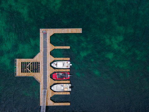 top view of modern wooden pier with motorboats in Norway