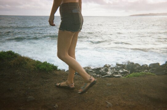 Walking by the Ocean Along the Rocky Shore During the Day