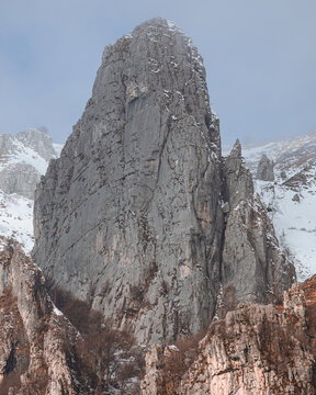 Dramatic winter view of Grignetta spires emerging from thick fog and low clouds. Moody alpine landscape with snow-covered rocky peaks in the Grigne mountains, Lecco, Italy - January 2026