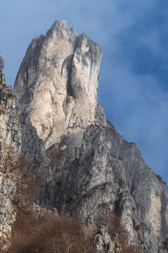 Dramatic winter view of Grignetta spires emerging from thick fog and low clouds. Moody alpine landscape with snow-covered rocky peaks in the Grigne mountains, Lecco, Italy - January 2026