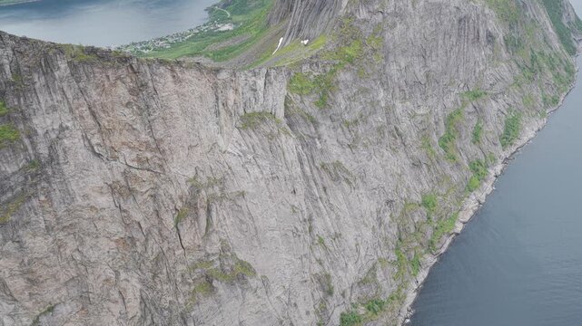 Aerial, reveal of impressive Segla cliffs and mountains on Senja island, rainy summer day. Amazing outdoor travel destination, hiking area in Norway. Wild nature in arctic Norway. Impressive outdoors.