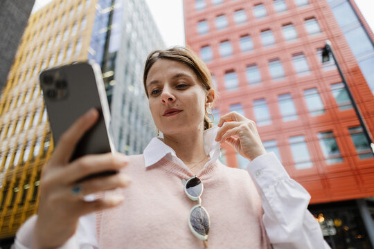 Woman using smartphone outdoors in urban city setting