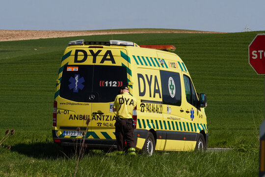 DYA ambulance and paramedic on standby in a green rural setting. Emergency response vehicle parked near fields in the Basque Country.