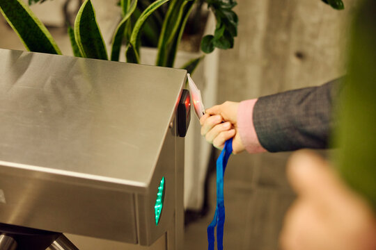 Woman scans her smart card at the turnstile