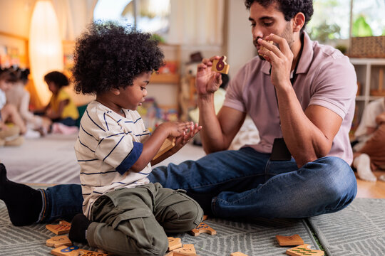 Teacher and child learn numbers with wooden blocks.