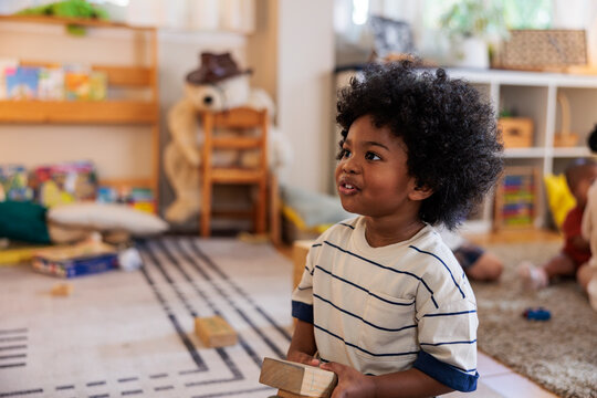 Young boy with blocks in a bright playroom.