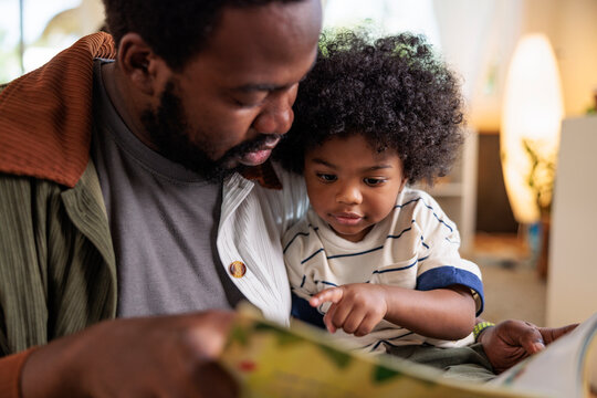 Father and child reading a book together.
