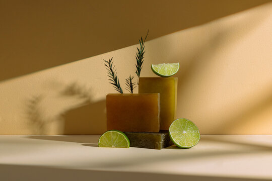 Soaps with lime and rosemary displayed on a warm neutral background