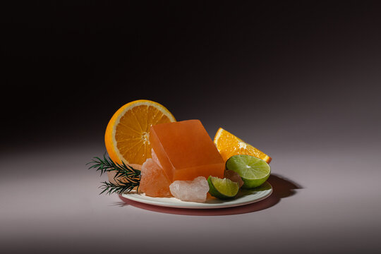 Citrus fruits and handmade soap on dark background