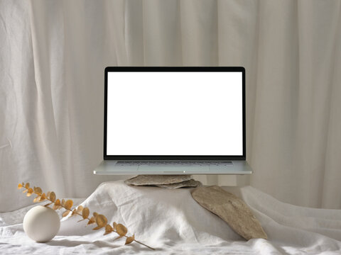 Laptop mockup on minimalist backdrop with stones and white linen