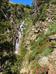 Water cascading through Meranges mountain landscape with blooming flowers